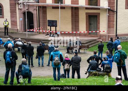 Wachstedt, Germania. 13 maggio 2021. I credenti si trovano di fronte alla chiesa del pellegrinaggio di Klüschen Hagis durante il pellegrinaggio alternativo degli uomini sotto il motto 'Vieni Signore, benedici noi' e guardano una televisione con una registrazione del vescovo. La Giornata dell'Ascensione è il giorno del pellegrinaggio degli uomini a Klüschen Hagis, nella diocesi di Erfurt. Come l'anno scorso, il tradizionale pellegrinaggio è annullato a causa di corona. Credit: Swen Pförtner/dpa/Alamy Live News Foto Stock