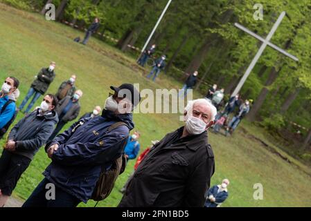 Wachstedt, Germania. 13 maggio 2021. La fedele protezione dal naso a bocca si trova di fronte a una croce di legno presso la chiesa di pellegrinaggio di Klüschen Hagis durante il pellegrinaggio alternativo degli uomini sotto il motto 'Vieni Signore, benedici'. La Giornata dell'Ascensione è il giorno del pellegrinaggio degli uomini a Klüschen Hagis, nella diocesi di Erfurt. Come l'anno scorso, il tradizionale pellegrinaggio è stato annullato a causa di corona. Credit: Swen Pförtner/dpa/Alamy Live News Foto Stock