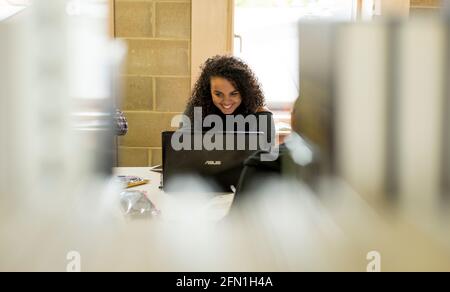 Femmina nero sesta forma studentessa, giovane donna in istruzione, giovane ragazza che guarda il laptop, nero femmina studentessa che lavora al portatile Foto Stock