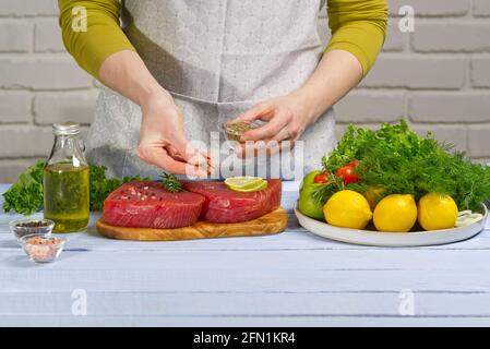 cottura bistecca di tonno. Bistecca di tonno rosso fresco dell'Atlantico, con spezie e pronta per la frittura. Il tonno albacora crudo fresco medaglione Foto Stock