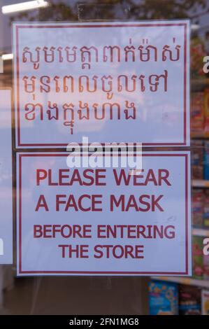 A causa di un focolaio di COVID - 19, il governo cambogiano ha imposto un mandato mascherato. Un supermercato mostra un cartello bilingue "indossare una maschera facciale" durante la pandemia del coronavirus. Phnom Penh, Cambogia. 29 Marzo 2020. © Kraig Lieb Foto Stock