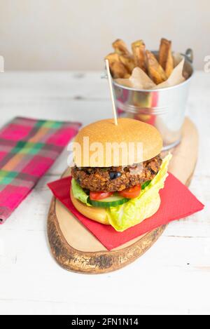 Hamburger vegetariano fatto in casa in un brioche con un lato di chip Foto Stock