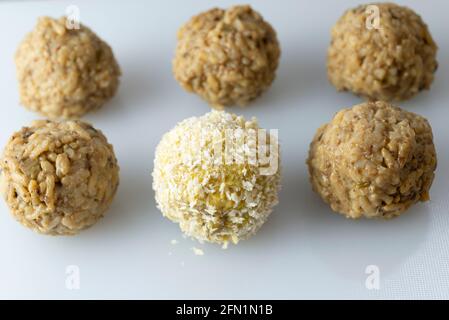 Fare arancini - rivestire le palle di riso in pangrattato. Foto Stock