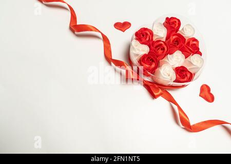 roses in una scatola di cuori di nastro rosso sfondo bianco. Concetto San Valentino e compleanno . alta qualità Foto Stock