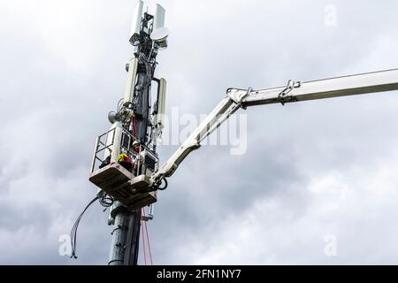 Ardara, Contea di Donegal, Irlanda. 13 maggio 2021. Gli ingegneri delle telecomunicazioni che lavorano per Secto installano le apparecchiature su un palo. Secto sta attualmente collaborando con le principali società di telecomunicazioni irlandesi per la creazione di ampie reti FTTH (Fibre to the Home Broadband) in tutta l'Irlanda rurale. Foto Stock