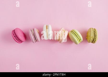 Colorati macaron da dessert su sfondo rosa pastello Foto Stock