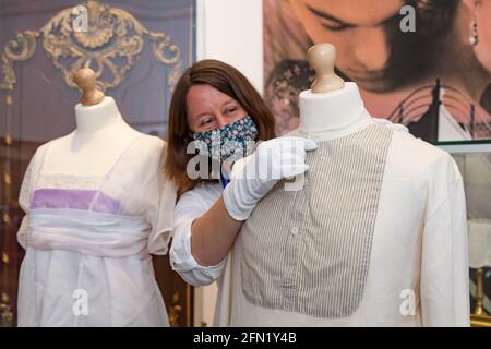 Worcester, Regno Unito. 13 maggio 2021. Claire Cheshire, curatore della Worcester City Art Gallery and Museum, con alcuni costumi indossati da Kate Winslet e Leonardo DiCaprio nel film Titanic di James Cameron, mentre il museo lancia una mostra Titanic: Honor and Glory. Le mostre includono manufatti autentici e cimeli del film del 1997, e saranno in mostra da lunedì 17 maggio. Peter Lopeman/Alamy Live News Foto Stock