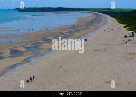 Vista su South Beach Tenby dalla cima della scogliera. La bassa marea ha esposto grandi aree di sabbia morbida con turisti che passeggiano lungo. Foto Stock