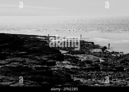 Una bella vista sul comune a Rest Bay, Porthcawl. Persone che si godono a piedi sulla spiaggia di sabbia esposta a bassa marea. Foto Stock