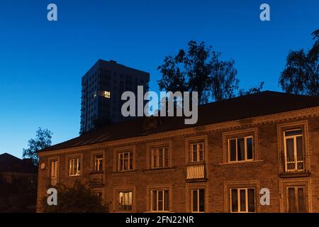 la luce brucia in una finestra della moltitudine in un edificio residenziale a più piani Foto Stock