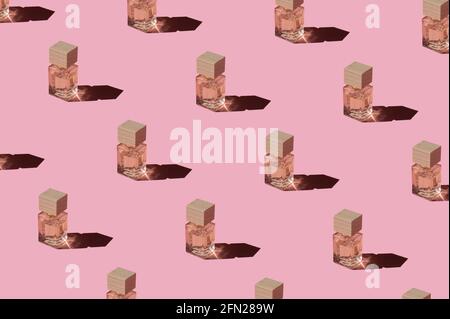 Modello di profumo Fragnance. Bottiglie in miniatura di profumo rosa donna su sfondo rosa pastello, vista dall'alto. Mockup di profumo fragrante. Luce solare alla moda Foto Stock