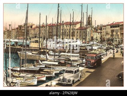 ST.TROPEZ Vintage anni '50 anni '60 Vista del porto con la pesca e barche a vela ormeggiate con Citroen Van francese e Peugeot auto parcheggiata, caffè e ristoranti dietro. Côte Azzurra Costa Azzurra a sud della Costa Azzurra. Saint-Tropez pittoresco, cafe' e porto fiancheggiato da negozi e una popolare destinazione alla moda alla moda, alla vela e yacht di lusso. Foto Stock