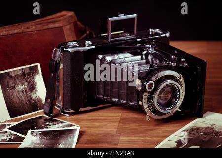 una vecchia fotocamera su un tavolo con vecchie immagini Foto Stock