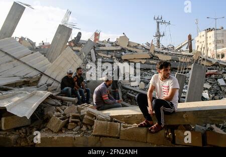 Gaza, Palestina. Maggio 13 2021: I palestinesi ispezionano le loro case distrutte dopo uno sciopero aereo israeliano nella striscia di Beit Lahia nella parte settentrionale di Gaza. L'esercito israeliano ha lanciato centinaia di attacchi aerei sulla striscia di Gaza dall'inizio della settimana, mentre i militanti palestinesi hanno lanciato più di 200 razzi, secondo l'esercito israeliano, in una delle peggiori violenze di sette anni nell'area. Credit: SOPA Images Limited/Alamy Live News Foto Stock