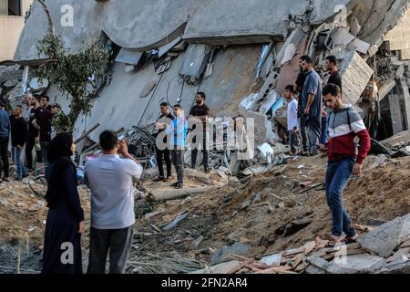 Gaza, Palestina. Maggio 13 2021: I palestinesi ispezionano le loro case distrutte dopo uno sciopero aereo israeliano nella striscia di Beit Lahia nella parte settentrionale di Gaza. L'esercito israeliano ha lanciato centinaia di attacchi aerei sulla striscia di Gaza dall'inizio della settimana, mentre i militanti palestinesi hanno lanciato più di 200 razzi, secondo l'esercito israeliano, in una delle peggiori violenze di sette anni nell'area. Credit: SOPA Images Limited/Alamy Live News Foto Stock