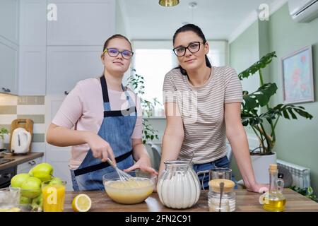 Mamma e figlia 12, 13 anni cuoco insieme torta di mele Foto Stock