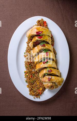 rotolo cotto con carne e riso su un piatto bianco. vista dall'alto. Foto Stock