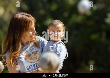 Mamma che tiene il suo ragazzo in un parco Foto Stock