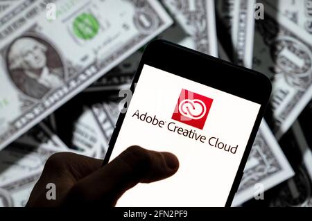 In questa illustrazione è illustrato il servizio di hosting dei file e l'accesso al software del computer di proprietà di Adobe Systems, Adobe Creative Cloud, il logo visualizzato su uno smartphone con la valuta USD (dollaro statunitense) in background. Foto Stock