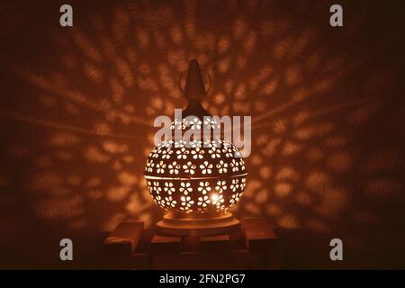 Lanterna araba ornamentale con candele accese di notte e scintillanti luci dorate del bokeh. Biglietto d'auguri natalizio, Foto Stock