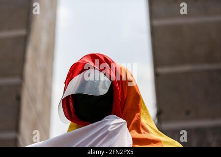 Un attivista indossa una bandiera arcobaleno mentre migliaia di attivisti si uniscono a una protesta per la festa del lavoro a Quezon City. Vari gruppi hanno chiesto diritti e benefici adeguati in materia di lavoro, come l'aumento minimo dei salari, l'assistenza finanziaria e le prove di massa dovute al COVID-19. Metro Manila, Filippine. Foto Stock