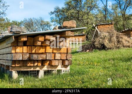 Il legno grezzo sotto la copertura nell'aria fresca asciuga naturalmente. Tavole di legno. Travi. Catasta di legno di essiccazione ad aria. Essiccazione all'aria del legno. Materiale da costruzione. Warehou legno Foto Stock