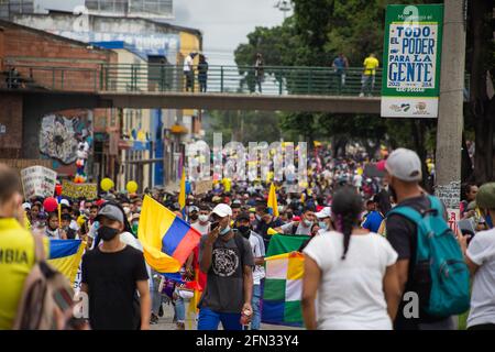 I manifestanti portano e fanno ondate bandiere colombiane durante le rivolte e le saccheggi nella città di Cali mentre i manifestanti si riuniscono durante il primo giorno di proteste anti-governative contro la riforma fiscale e la riforma sanitaria del presidente Ivan Duque nella città di Cali, Valle del Cauca, il 28 aprile 2021. Più tardi, in giornata, le manifestazioni rischiavano di disordini e diverse morti in casi di brutalità della polizia nel dipartimento della Valle del Cauca. Foto Stock