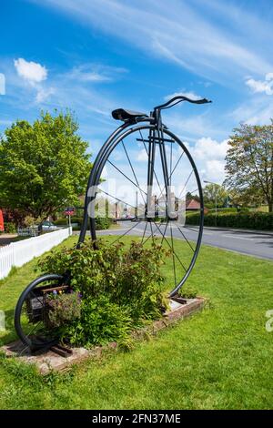 Bicicletta gigante Penny Farthing all'ingresso del villaggio di Sissinghurst, Kent, Regno Unito Foto Stock