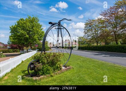 Bicicletta gigante Penny Farthing all'ingresso del villaggio di Sissinghurst, Kent, Regno Unito Foto Stock