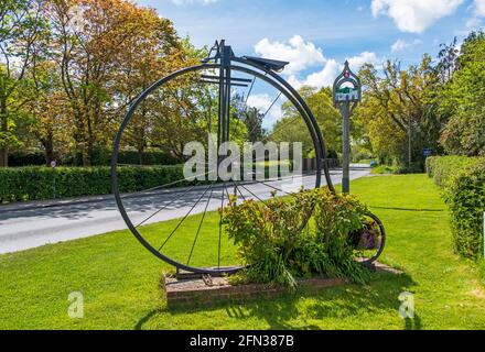 Bicicletta gigante Penny Farthing all'ingresso del villaggio di Sissinghurst, Kent, Regno Unito Foto Stock