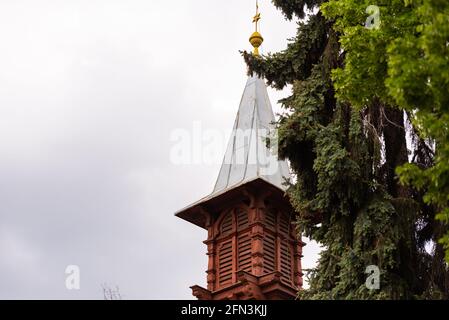 Vecchia torre di legno sullo sfondo di un albero con coni. Una torre in una delle case private a Brno nella Repubblica Ceca. Foto Stock