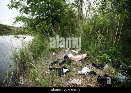 Del Rio, Stati Uniti. 13 maggio 2021. I vestiti migranti scartati sono visti sul lato americano del Rio Grande. Secondo stime non ufficiali, circa 200,000 migranti sono passati negli Stati Uniti lungo il confine meridionale dal febbraio 2021. Credit: SOPA Images Limited/Alamy Live News Foto Stock