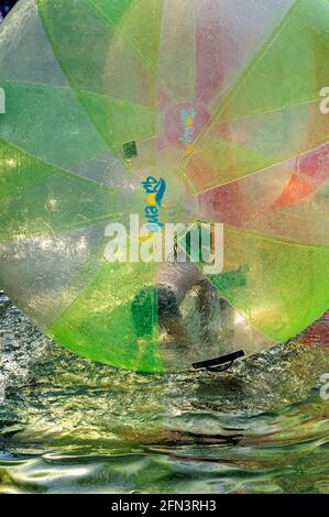 Bambini che giocano su un giro gonfiabile di veglia d'acqua (palla di Zorb) al Malecon 2000 a Guayaquil Ecuador Foto Stock