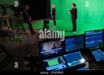 12 maggio 2021, Sassonia, Lipsia: Gli interpreti sordi Antje Seifert (l) e Katja Fischer traducono un "Polizeiruf 110" di nuova produzione in linguaggio dei segni davanti a due telecamere in uno studio di Mitteldeutscher Rundfunk (MDR). Gli interpreti stanno trasmettendo il Polizeiruf di Halle, che è stato prodotto per celebrare il 50 ° anniversario della serie del crimine, per non udenti e non udenti spettatori. In questo modo, MDR desidera creare un accesso ai programmi senza barriere. "An der Saale hellem Strande" sarà presentato il 30 maggio presso l'emittente pubblica tedesca Ersten. Foto: Hendrik Schmidt/dpa-Zentralbild/dpa Foto Stock