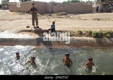 I ragazzi nuotano per rinfrescarsi nel caldo estivo durante l'operazione Mosul del 2016-2017 vicino a Mosul. Foto Stock