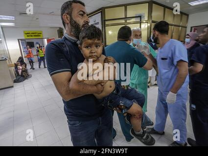 (NOTA PER GLI EDITORI: L'immagine contiene contenuti grafici). Un bambino palestinese ferito viene portato all'ospedale di al-Shifa per ricevere cure dopo uno sciopero aereo israeliano nella città di Gaza. In risposta a giorni di violenti scontri tra le forze di sicurezza israeliane e i palestinesi a Gerusalemme, varie fazioni militanti palestinesi a Gaza hanno lanciato attacchi razzi dal 10 maggio che hanno ucciso almeno sette Israeliti fino ad oggi. Il ministero della salute della striscia di Gaza ha affermato che almeno 109 palestinesi, tra cui 28 bambini, sono stati uccisi durante i recenti rappresaglie israeliane. Foto Stock