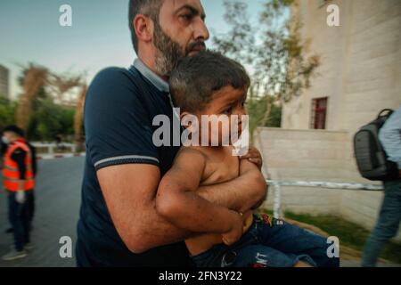 Gaza, Palestina. Maggio 13 2021: CONTENUTO GRAFICO - un bambino palestinese ferito viene portato all'ospedale di al-Shifa per ricevere cure dopo un attacco aereo israeliano nella città di Gaza. In risposta a giorni di violenti scontri tra le forze di sicurezza israeliane e i palestinesi a Gerusalemme, diverse fazioni militanti palestinesi a Gaza hanno lanciato attacchi razzi dal 10 maggio che hanno ucciso almeno sette israeliani fino ad oggi. Il ministero della salute della striscia di Gaza ha affermato che almeno 109 palestinesi, tra cui 28 bambini, sono stati uccisi durante i recenti rappresaglie israeliane. Credit: Abaca Press/Alamy Live New Foto Stock