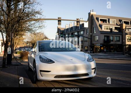 Un'auto elettrica Tesla Model 3 viene addebitata presso una stazione di ricarica EV sul marciapiede sul lago Oswego, Oregon, giovedì 11 marzo 2021. Foto Stock