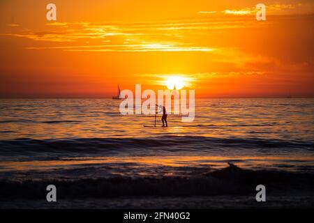 Silhouette al tramonto di paddle board su un mare. Relax sull'oceano. Alba sul mare e bellissimo paesaggio nuvoloso. Colorato mare spiaggia tramonto. Stagcape Foto Stock