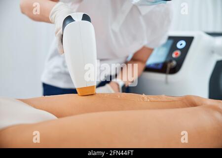 Medico esperto che esegue una procedura di rimozione dei capelli laser Foto Stock