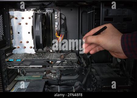 Il tecnico di informatica elettronica pulisce l'hardware del PC dalla polvere Foto Stock