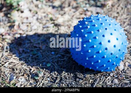 piccola palla blu con punte che giacciono a terra Foto Stock