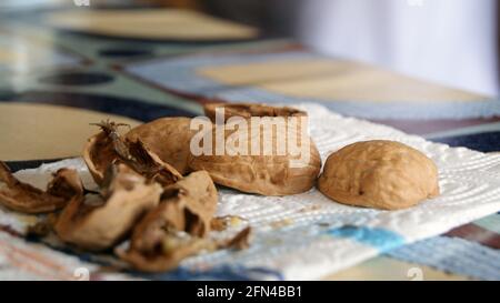 Gusci di noce rotti su un tavolo da cucina. Mangia noci in autunno. Foto Stock