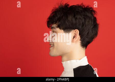 Ritratto dell'uomo asiatico isolato su sfondo rosso dello studio con copyspace Foto Stock