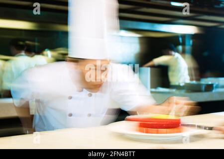Ritratto di chef asiatico decorare la torta Foto Stock
