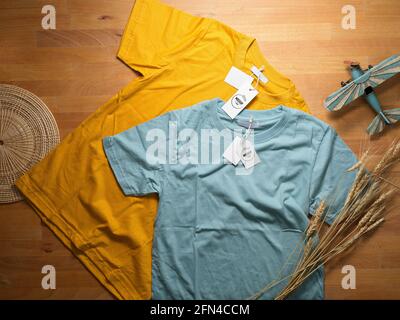 Vista dall'alto della t-shirt gialla e blu con fock in su le etichette di prezzo su tavola di legno Foto Stock