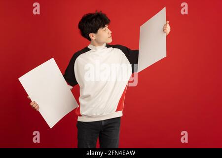 Ritratto dell'uomo asiatico isolato su sfondo rosso dello studio con copyspace Foto Stock