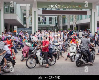 Area congestionata come molti genitori arrivano alle porte della scuola su moto e scooter nel corso della scuola pomeridiana, da Nang, Vietnam Foto Stock