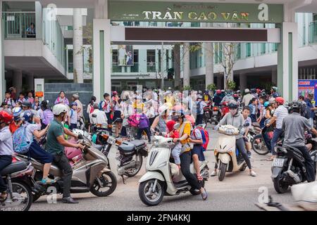 Area congestionata come molti genitori arrivano alle porte della scuola su moto e scooter nel corso della scuola pomeridiana, da Nang, Vietnam Foto Stock