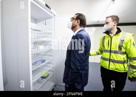 Ebersberg, Germania. 14 maggio 2021. Klaus Holetschek (CSU), Ministro della Sanità della Baviera (l), è presentato un frigorifero con vari vaccini Corona da Liam Klages, capo del centro di vaccinazione, nella volta del centro di vaccinazione durante una visita ministeriale dal centro di vaccinazione di Ebersberg. Durante la visita, il ministro impara a conoscere l'esperienza del centro di vaccinazione con il concetto di passaporto di vaccinazione digitale "passaporto sanitario digitale vivo". Credit: Attias Balk/dpa/Alamy Live News Foto Stock